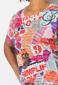 Multikleurige T-shirt met korte mouwen met een mix van vormen, patronen en cijfers in rood, roze, oranje en blauw met een gestructureerde afwerking.