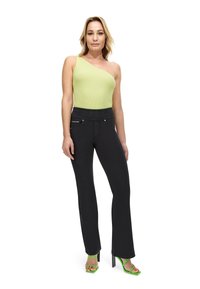 Vihreä limen värinen yksiolkaiminen ribbipaita; korkea vyötärö mustat housut metallikoristeilla; vihreät korkeat sandaalit ohutnauhoin.