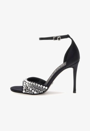 Sandal in satin nero con tacco alto e cinturino alla caviglia, dotata di una fascia per le dita decorata con pietre brillanti in argento e strass trasparenti.