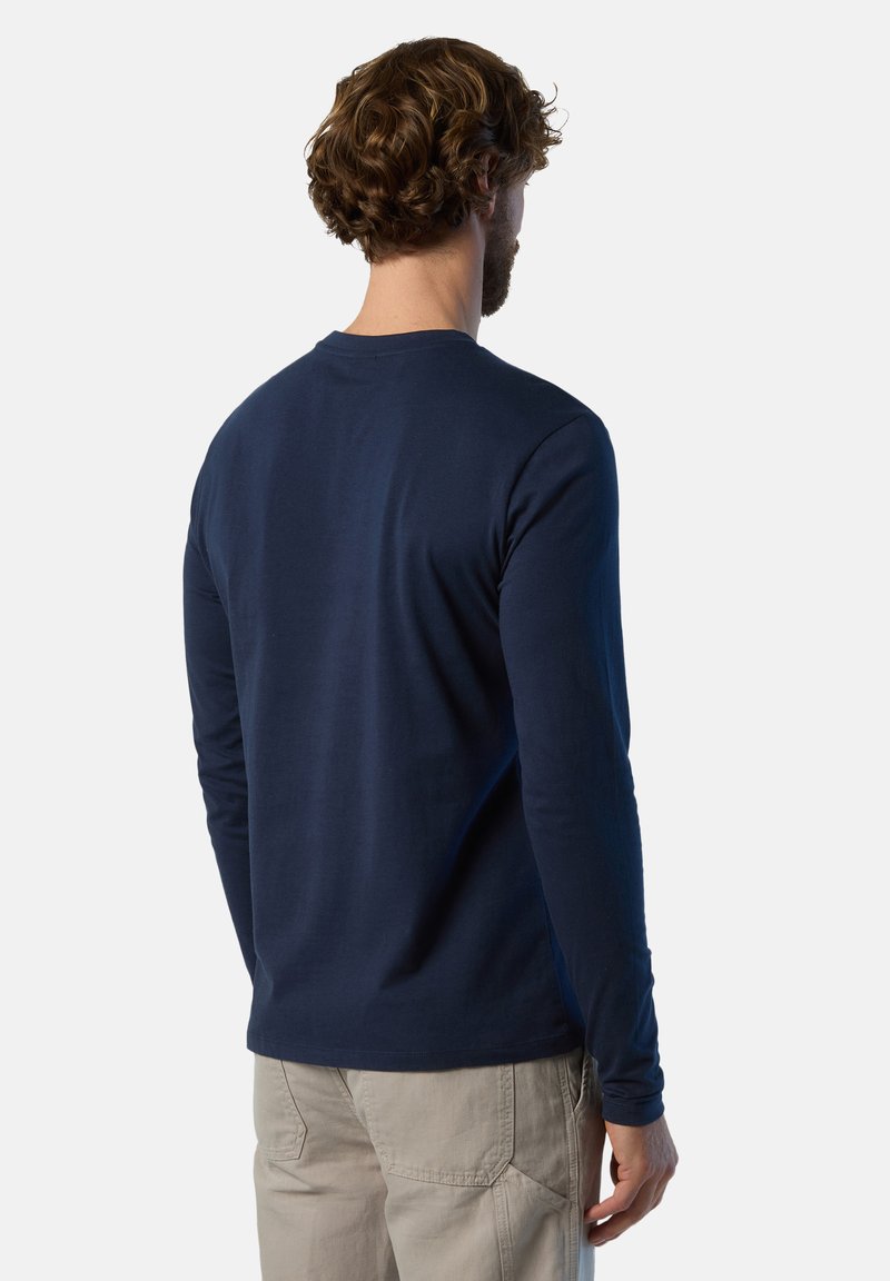 Mörkblå långärmad skjorta gjord av mjuk bomull, med rundad halsringning och en figurnära silhuett, där minimal sömnad är synlig på baksidan.