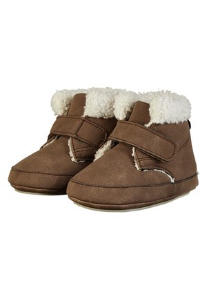 Braune Babyschühchen mit weicher weißer Fleece-Fütterung und einem einzigen Klettverschlussriemen vorne, entworfen für Wärme und Komfort.