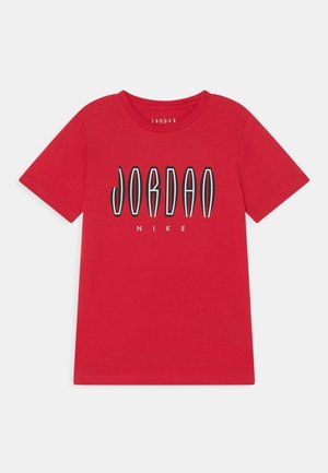 Camiseta roja de manga corta con texto "JORDAN" en negro y blanco estirado y logo blanco más pequeño de "NIKE" debajo en la parte delantera.