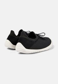 Scarpe sportive in maglia nera con tomaia testurizzata, dotate di collo a coste, design con lacci e suola bianca simile a una calza per flessibilità.