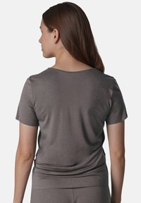 Camiseta gris de manga corta con un corte relajado, textura suave y escote redondeado. Costuras visibles y diseño minimalista.