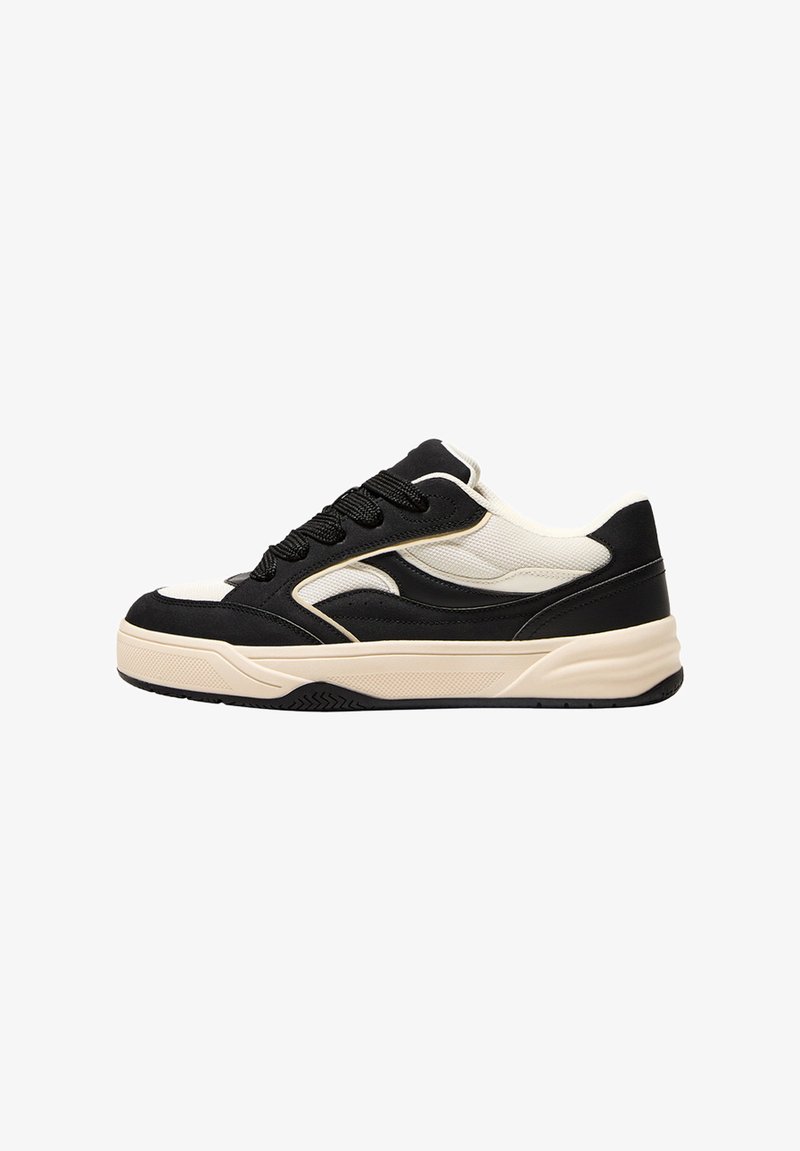 Schwarträna och krämfärgade sneakers med en mönstrad design, funktionell mesh-överdel, svarta snören, och en kraftig sula med gummitredmönster.