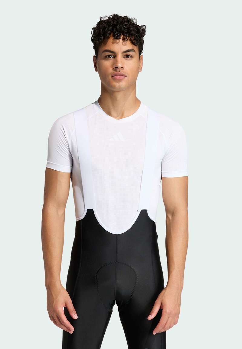 Fietsbroek met bretels, voorzien van een aansluitend, ademend wit bovenstuk en een zwarte onderkant. Voorzien van verstelbare banden en een gewatteerde zit voor comfort.