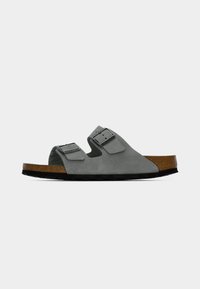 Γκρι σουέντ σανδάλια με δύο ρυθμιζόμενες αγκράφες, πάτο από φελλό και μαύρη καουτσούκ σόλα. Ανοιχτή μύτη για καλύτερο αερισμό.