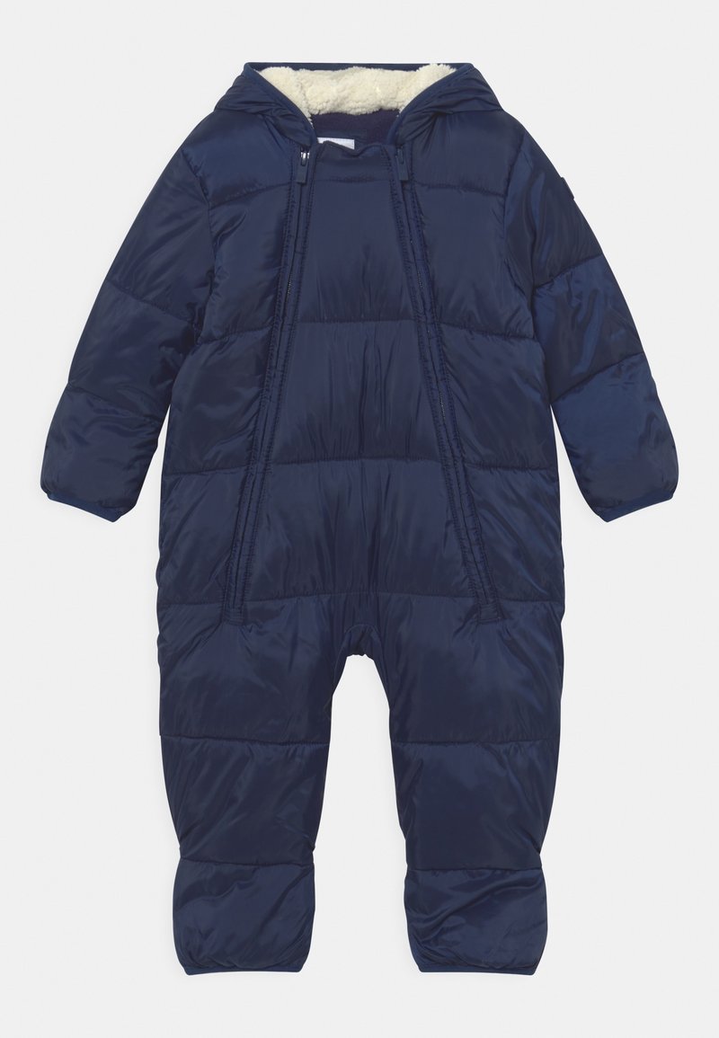 Combinaison de neige matelassée bleu marine pour bébé avec capuche doublée en polaire blanche et deux fermetures éclair devant s’étendant le long des jambes pour un habillage facile.