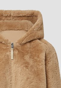 Tan nepbont zip-up jack met capuchon, voorzien van een gladde voering en een kleine zilveren rits met een label. Zachte, gestructureerde oppervlakte.