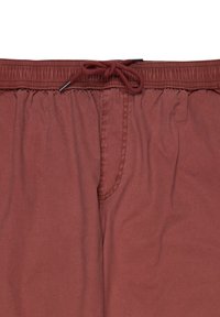 Bordeauxkleurige zwembroek met een elastische tailleband, trekkoordsluiting en zijzak. De stof lijkt zacht met een gladde textuur.