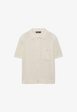 Rövid ujjú bézs kötött kardigán gallérral, elülső gombokkal és egy mellkasi zsebbel.