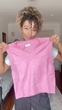 Helles rosa ärmelloses Sweatshirt mit V-Ausschnitt, aus weichem Stoff gefertigt, mit gerippten Akzenten am Ausschnitt und Saum. Keine nennenswerten Muster.