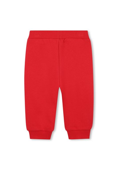 Pantalon de survêtement en coton rouge avec une taille et des poignets côtelés. Présente un design simple et droit sans poches ni ornements.