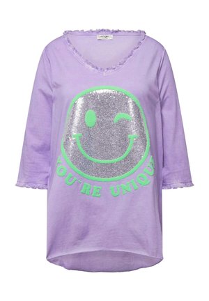 T-shirt long violet à manches longues avec un graphique de visage souriant pailleté argent et le texte vert "VOUS ÊTES UNIQUE." Encolure brut et poignets.
