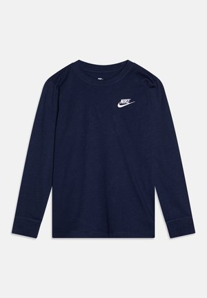 T-shirt Nike bleu marine à manches longues avec logo blanc sur la poitrine gauche et col rond, posé à plat sur un fond clair.