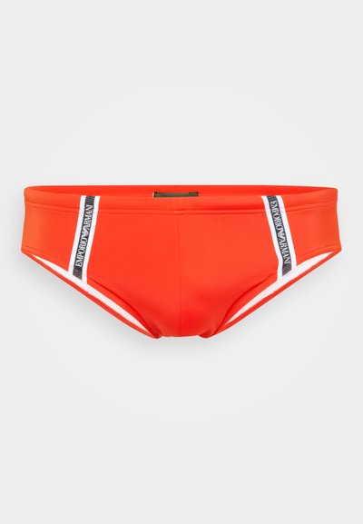 Rote Schwimmbriefs aus glattem Stoff, mit weißen Seitenstreifen und einem Logo-Akzent. Taillierte Passform mit klassischem Design.