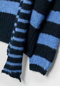 Gestrickter Pullover mit dunkelblauen und hellblauen horizontalen Streifen, aus strukturiertem Stoff und mit gerippten Bündchen, die leichte Ausfransungen aufweisen.
