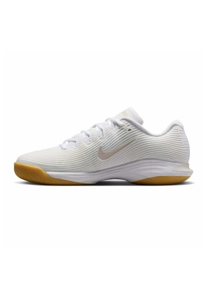 Witte Nike sportschoen met gestructureerd bovenwerk, lichtbeige logo, witte veters en gumrubberen zool gezien van opzij.