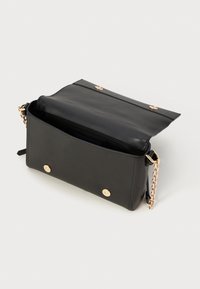 Black leather bag with a smooth texture, gold hardware accents, a chain strap, and a spacious interior secured by two snap buttons.