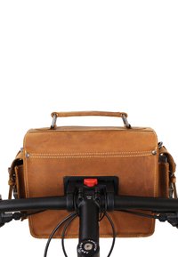 Sac messager en cuir marron avec une poignée supérieure, couture visible et une plaque de montage noire attachée au guidon d'un vélo.