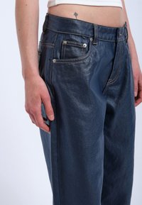 Jeans i mörkblått denim med en lätt lyster; har fem fickor, kontrasterande guldstickningar och en rak passform.