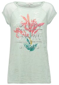 Camiseta corta de manga en verde menta con un acabado texturizado. Presenta un gráfico floral y el texto "HISTORIAS DE PRIMAVERA ARDIENTE" en color plata.