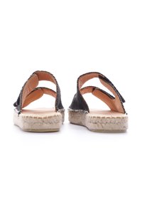Sandali espadrilles neri con due larghe cinghie, fodera interna beige e suola in corda di juta. Design a schiena aperta con una finitura testurizzata.