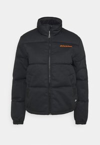 Doudoune noire avec un col montant, fermeture éclair, poignets élastiques et logo orange sur la poitrine. Design matelassé pour l'isolation.