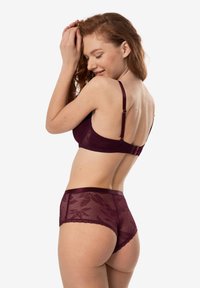 Bordowa koronkowa biustonosz i zestaw majtek w wyższym stanie z motywem kwiatowym, z regulowanymi ramiączkami i falbaniastymi krawędziami, prezentujący przezroczysty materiał.