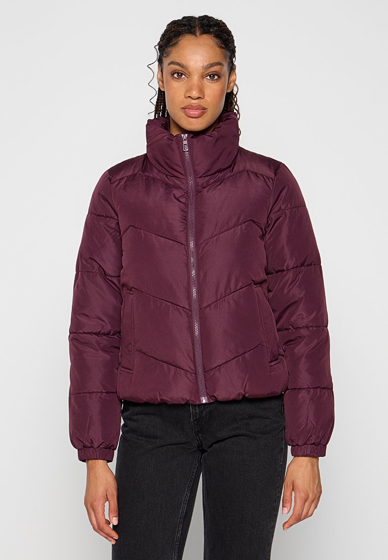 Bordeaux pufferjack met een hoge kraag, rits aan de voorkant en elastische manchetten. Kenmerkend zijn de chevron-quilting en zijzakken. Glad textuur.