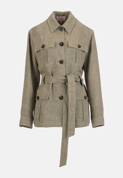 Bézs, hosszú ujjú, gombos dzseki gallérral, négy elülső cipzáras zsebbel és hozzáillő anyagövvel a deréknál megkötve.