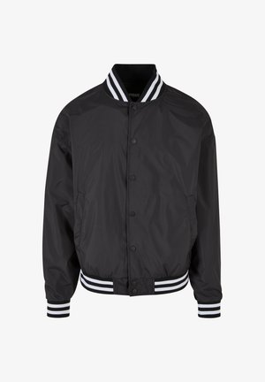 Černá bomber bunda vyrobená z hladkého materiálu, s předním zapínáním na patentky a pruhovanými manžetami a límcem v bílé a černé barvě.