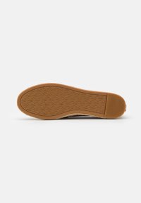 Rubber sole with a textured pattern, featuring a light brown color. The design is flat with a slightly raised heel.