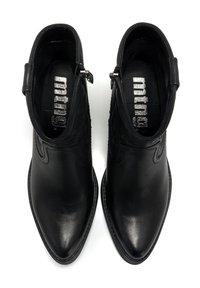 Botas de cuero negro hasta el tobillo con punta afilada, costuras decorativas y cremalleras laterales. Textura suave y diseño elegante con un perfil minimalista.