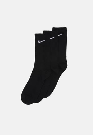 Black cotton socks in a pack of three. Ribbed texture with a white Nike logo embroidered on the upper part. Classic crew length design.
