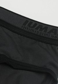 Zwarte sportonderbroek met een zachte elastische tailleband met logo-tekst. De stof is glad en lichtgewicht, met een naadloos ontwerp.