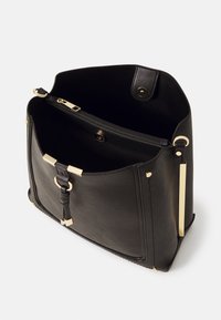 Czarna skórzana torba ze złotymi elementami, z otwartą górą, wewnętrzną kieszenią na zamek oraz o usztywnionym, prostokątnym kształcie.