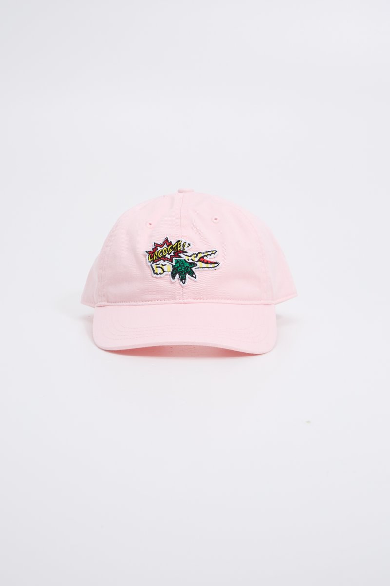 Gorra de béisbol de algodón rosa con un logo bordado de Lacoste que presenta un cocodrilo y hojas de palma en la parte frontal. Visera curvada y correa ajustable.
