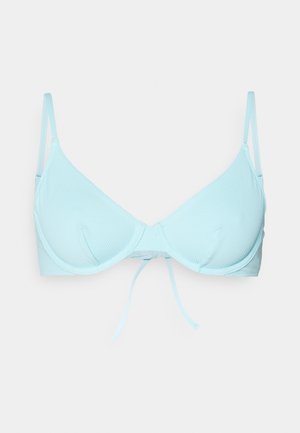 Svijetloplava grudnjak od teksturirane mrežaste tkanine, trokutasti umeci, podesive naramenice i prednje vezivanje. Ima glatku završnicu.