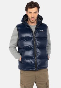 Navyblauer Puffer-Weste mit Kapuze, Reißverschluss vorne, gestepptem Design und zwei Seitentaschen. Mit einem Logo auf der Brust, aus glänzendem Material gefertigt.