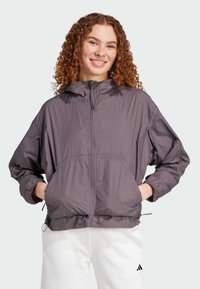 Lätt, huva, lila vindjacka med dragkedja fram, elastiska ärmslut och framfickor. Slät textur med en avslappnad passform.