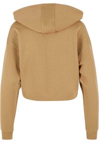 Sweat à capuche court beige avec manches longues, poignets côtelés et une couture verticale au centre de la capuche, vu de dos.