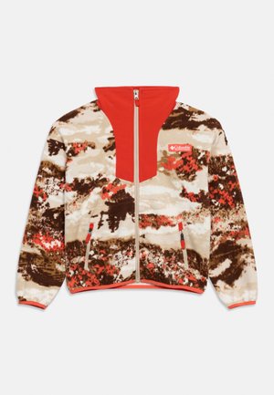 Veste en polaire avec un motif abstrait marron, beige et rouge, col haut rouge, fermeture éclair frontale, poches latérales zippées et logo Columbia sur la poitrine.