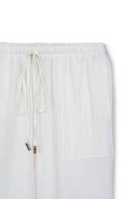 Weiße Leinenhose mit einem elastischen Bund, Kordelzugverschluss und zwei Seitentaschen. Leichter, strukturierter Stoff mit lockerer Passform.