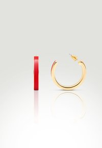 Goldene Creolenohrringe mit einer glatten, roten Emaille-Innenverkleidung. Das Design zeichnet sich durch eine schlanke, geschwungene Form und einen standardmäßigen Steckverschluss aus. Reflexive Oberfläche.