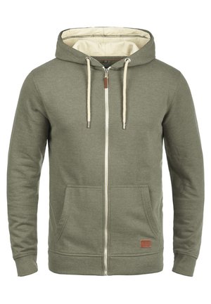Olivově zelená mikina s zipem vyrobená z měkké tkaniny, s béžovou podšívkou, šňůrkami, předními kapsami a koženou nášivkou s logem.