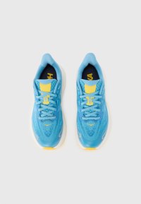 Baskets de sport bleues avec partie supérieure en mesh, accents jaunes, bout arrondi, lacets plats et semelle blanche épaisse pour amorti et soutien.