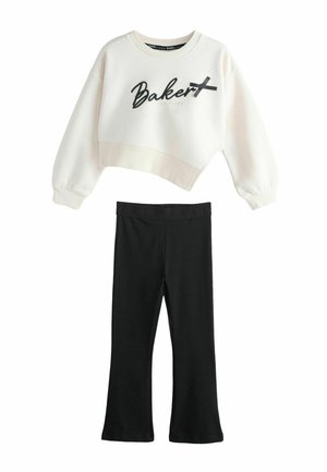 Hvid cropped sweatshirt med "Baker" tekst og sort sløjfedetalje, kombineret med sorte vidde bukser med elastisk talje.