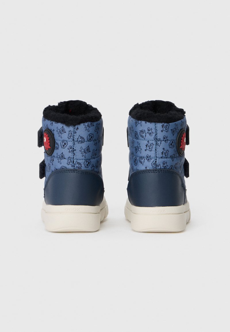 Niebieskie botki za kostkę z czarnym futerkiem w środku, posiadające wzorzystą tekstylną cholewkę, gładkie akcenty z granatowej skóry oraz czerwony detal z logo.