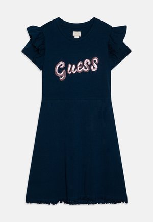 Vestido azul marino de manga corta con mangas con volantes y "Guess" en lentejuelas rosas en el pecho, falda acanalada y escote redondo.